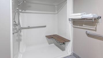 Un espace douche équipé d’une barre d’appui, d’une étagère et d’un porte-serviettes.