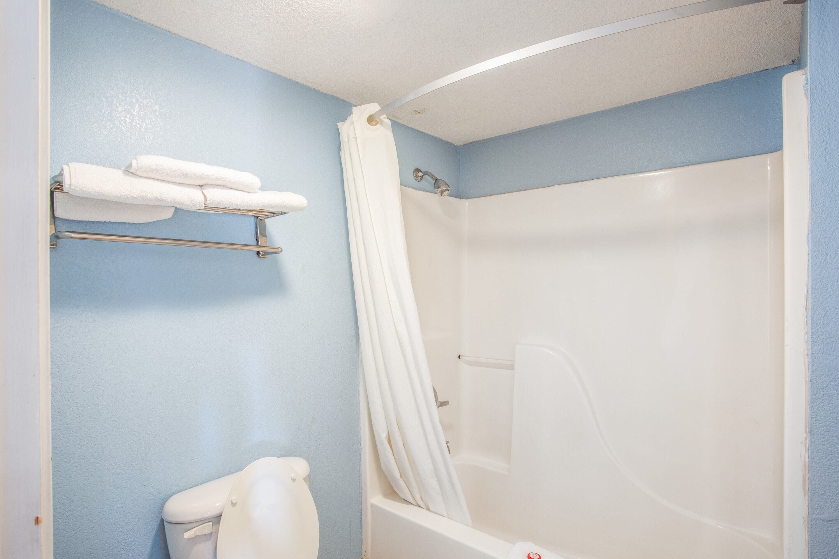 Une salle de bain équipée d’une baignoire, de toilettes et d’un porte-serviettes avec des serviettes.