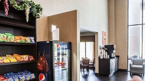 A hotel lobby with a snack shelf, a Pepsi refrigerator, a coffee station, and a seating area. - Comfort Inn Lees Summit @ Hwy 50 & Hwy 291 (Lee's Summit)