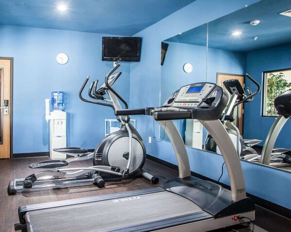 A gym with treadmills, an elliptical, and a water dispenser.