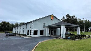 Un motel con entrada cubierta, estacionamiento y un letrero que indica el número 8.