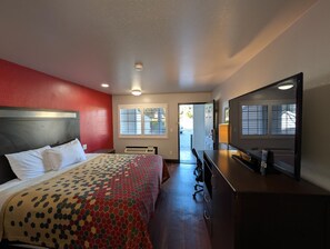 A hotel room with a bed, a desk, a TV, and a window. - Americas Best Value Inn Sacramento Old Town (Sacramento)