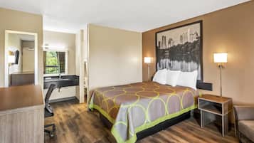 Une chambre d’hôtel avec un lit, un bureau, une chaise et un tableau représentant un paysage urbain.