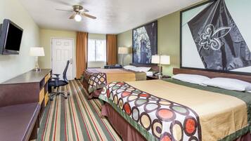 A hotel room with a bed, desk, chair, and a television.