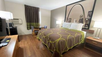 A hotel room with a bed, a desk, a chair, a lamp, and a cityscape mirror.
