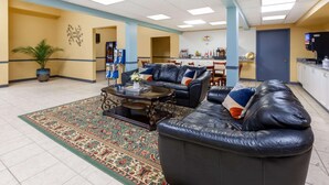 A spacious lobby with a leather sofa set, a coffee table, and a patterned rug. - Super 8 by Wyndham Newcomerstown (Newcomerstown)