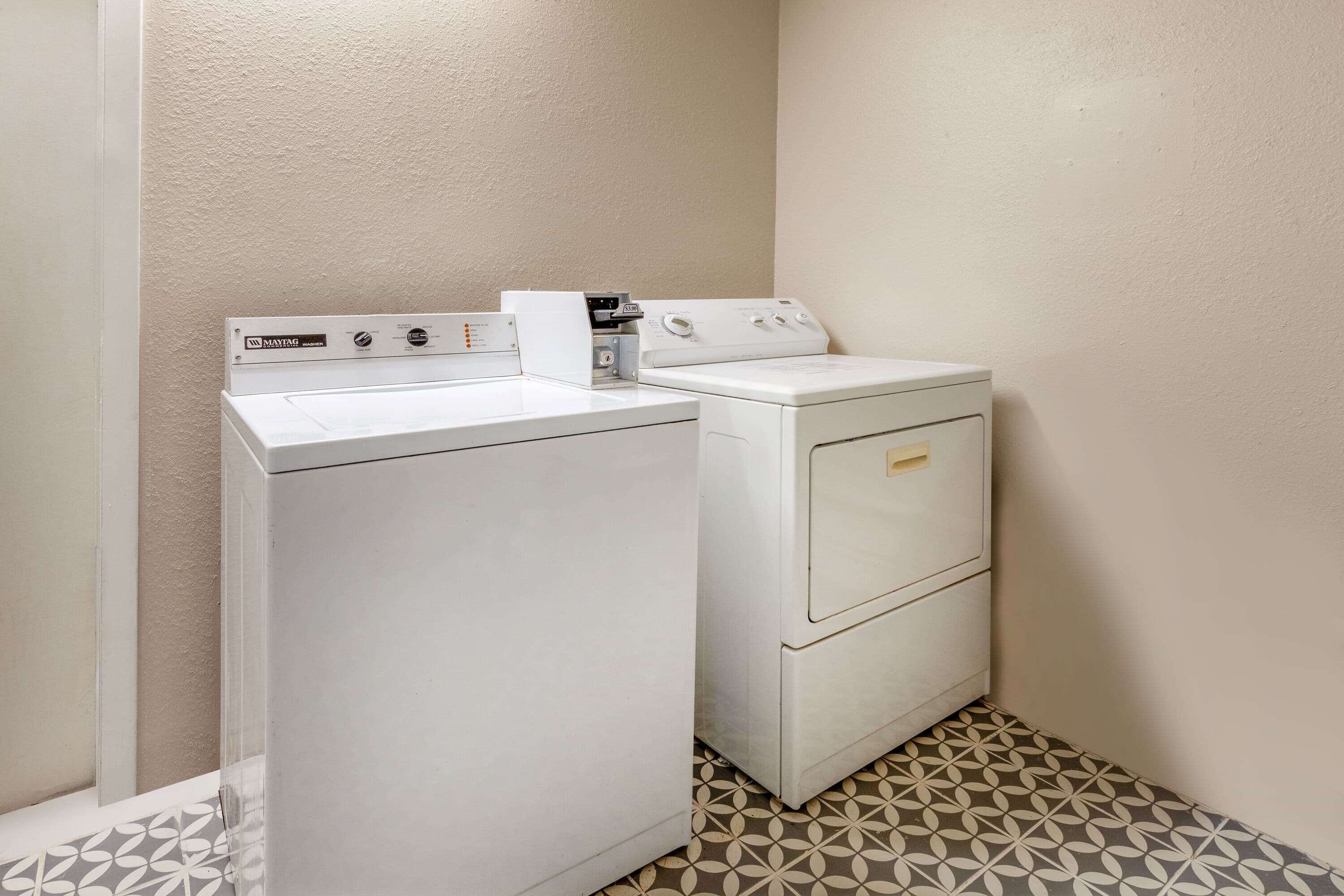 A laundry area with a front-loading washer and a stacked dryer.