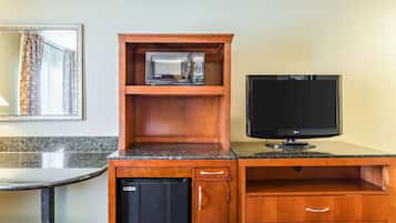 A compact kitchenette with a microwave, a television, and a small refrigerator.