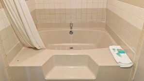 A bathroom with a bathtub, a sink, and a towel rack. - Inn of Loudon (Loudon)