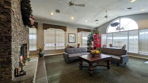 A spacious living area with a fireplace, sofas, a coffee table, and large windows. - Inn of Loudon (Loudon)