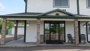 A two-story building with a covered entrance and a garage door. - AmeriVu Inn and Suites - Stanley (Stanley)