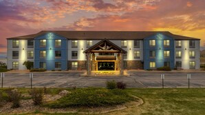 A multi-story hotel with a central entrance, a parking lot, and a landscaped area in front. - Comfort Inn & Suites Summerset - North Rapid City (Blackhawk)