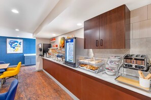 A modern kitchen with a refrigerator, toaster, and breakfast bar. - Comfort Inn & Suites Summerset - North Rapid City (Blackhawk)