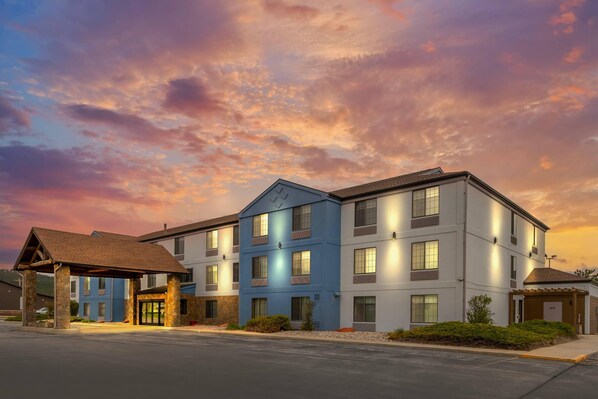 A multi-story hotel with a covered entrance, a blue building, and a parking lot. - Comfort Inn & Suites Summerset - North Rapid City (Blackhawk)