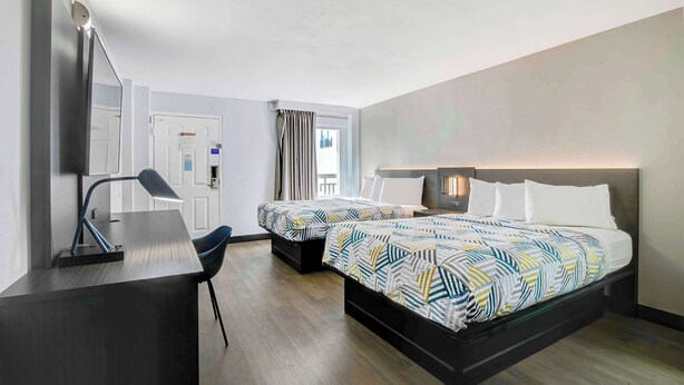 Une chambre d’hôtel moderne, dotée d’un grand lit, d’un bureau et d’une chaise.