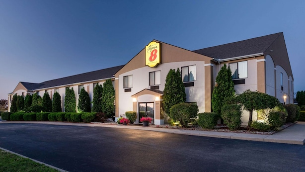 Un hotel Super 8 con diseño moderno, que presenta un cartel grande, múltiples ventanas y jardines bien cuidados.