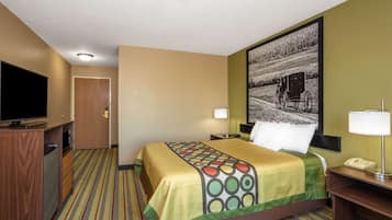 A hotel room with a bed, a television, a desk with a lamp, and a painting on the wall.