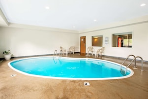 Piscina interior com indicador de profundidade de 3 pés, rodeada por paredes brancas e teto com iluminação embutida.