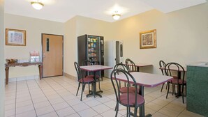 A dining area with a vending machine, a refrigerator, and a counter. - Super 8 by Wyndham Bonne Terre (Bonne Terre)
