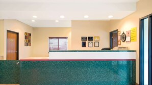 A reception area with a green marble counter, framed certificates on the wall, and a clock. - Super 8 by Wyndham Bonne Terre (Bonne Terre)