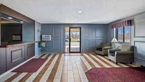 A hotel lobby with a reception desk, seating area, and a view of the parking lot. - Econo Lodge Inn & Suites Auburn (Auburn)