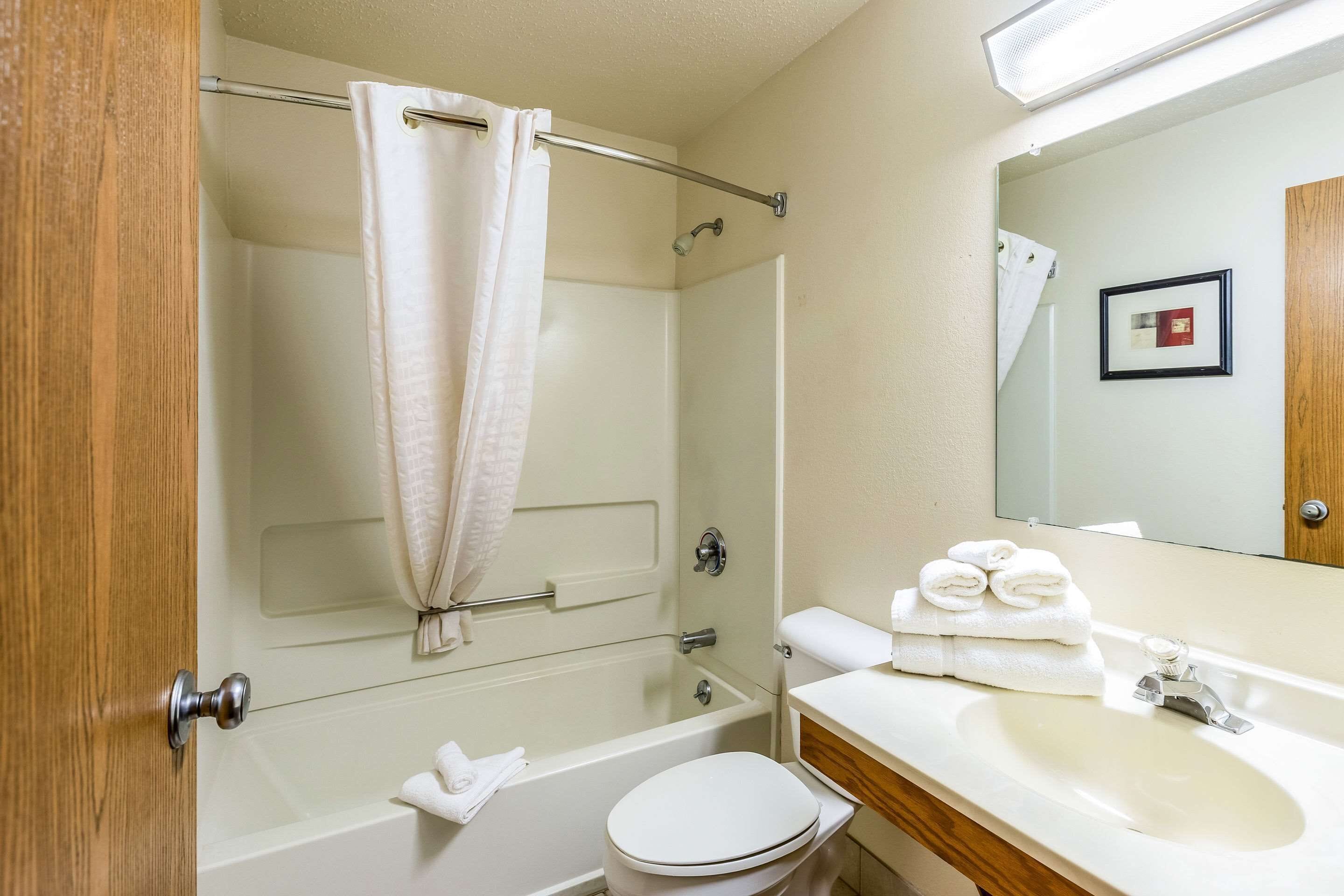 A bathroom with a bathtub, toilet, and sink.