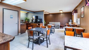 A hotel room with a dining area, a kitchenette, a sofa, and a TV. - Econo Lodge Inn & Suites Auburn (Auburn)