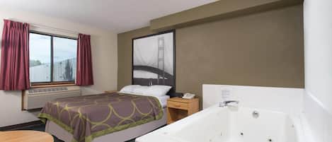 Ein Hotelzimmer mit Bett, großem Fenster mit Vorhängen, Klimaanlage, Nachttisch mit Telefon und einer Badewanne.