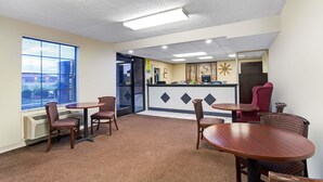 A hotel lobby with a reception desk, several round tables, and chairs. - Super 8 by Wyndham Clarksville East (Clarksville)