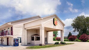A hotel with a large sign, a covered entrance, and a parking lot. - Super 8 by Wyndham Clarksville East (Clarksville)