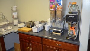 A kitchenette with a coffee maker, toaster, and cereal boxes. - Super 8 by Wyndham Clarksville East (Clarksville)