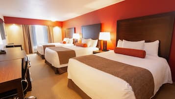 Ein Hotelzimmer mit zwei Betten, einem Schreibtisch und einem Stuhl.