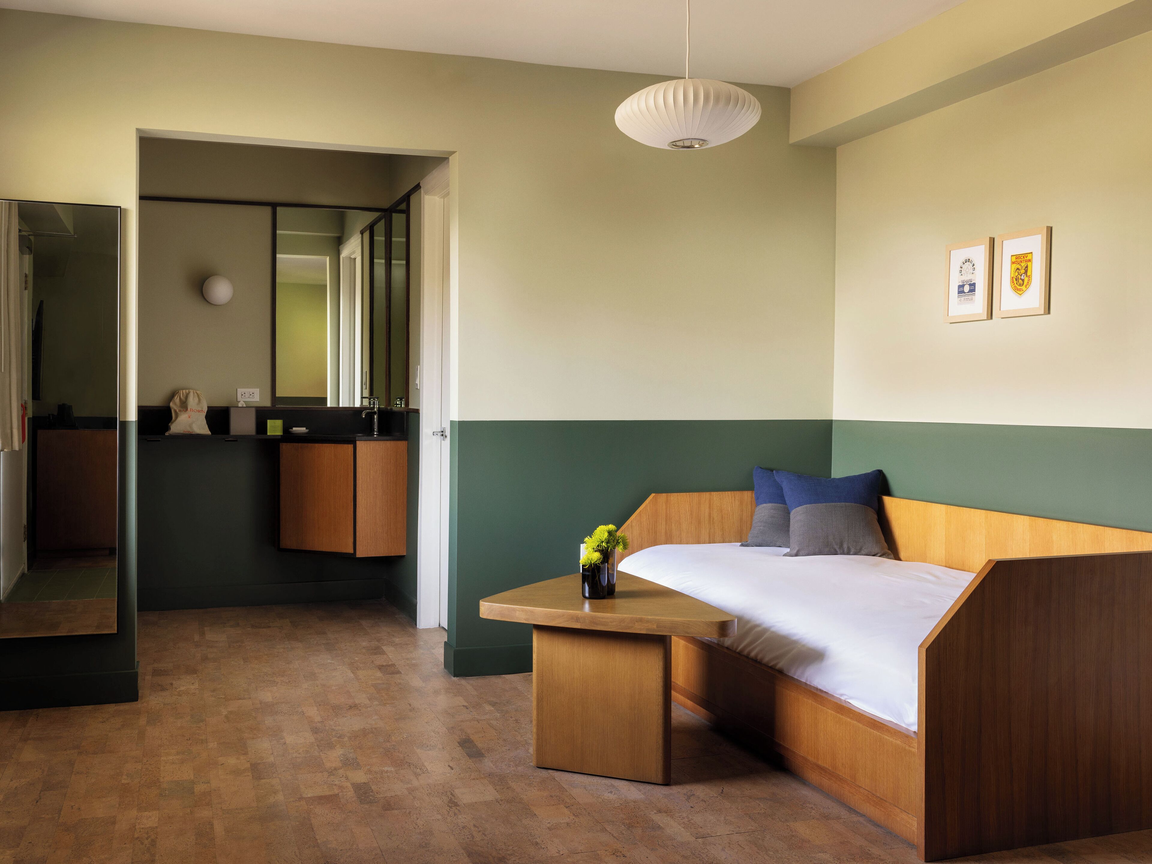 A modern bedroom with a wooden bed, a small table, and a mirror.