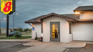 A Super 8 motel with a single-story structure, a front door, and a parking sign. - Super 8 by Wyndham Jamestown (Jamestown)