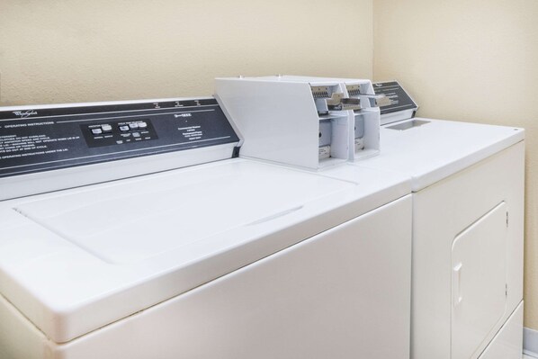 A front view of a Whirlpool washer and dryer unit with a control panel and a detergent dispenser. - Super 8 by Wyndham Jamestown (Jamestown)