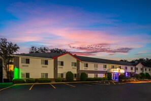 A motel with a parking lot and a building with a red roof. - Super 8 by Wyndham Medina (Medina)