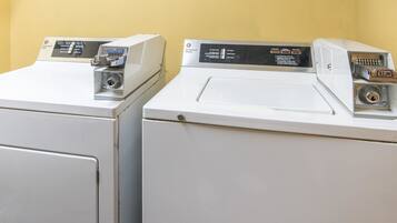 Two front-loading washing machines with control panels, set against a yellow wall.