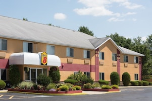 Un hotel Super 8 con techo plano, ventanas amplias y estacionamiento.