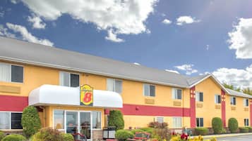 Experience the charm of this stylish hotel with a Supper 8 sign above the entrance, surrounded by a beautifully maintained garden and a convenient bicycle parking area.
