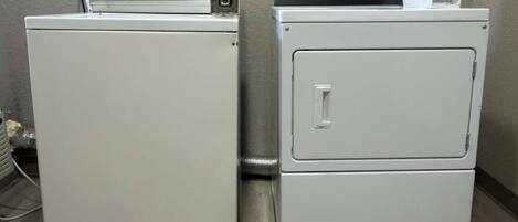 Dos electrodomésticos blancos apilados, probablemente una lavadora y un secadora, con un panel de control en la parte superior.
