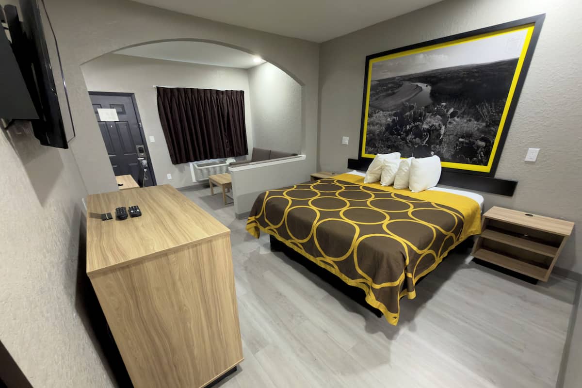 A modern hotel room with a bed, a desk, and a large window.