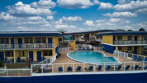 Alberca al aire libre, sombrillas en la alberca y camastros