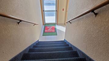 A staircase leading to an exit door with a red EXIT sign above it.