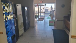 Een hal met automaten, een receptie en uitzicht op buiten.