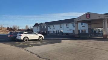 A Super 7 Inn with a parking lot and two parked cars.