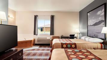 Una habitación de hotel con dos camas, televisión, escritorio y baño.