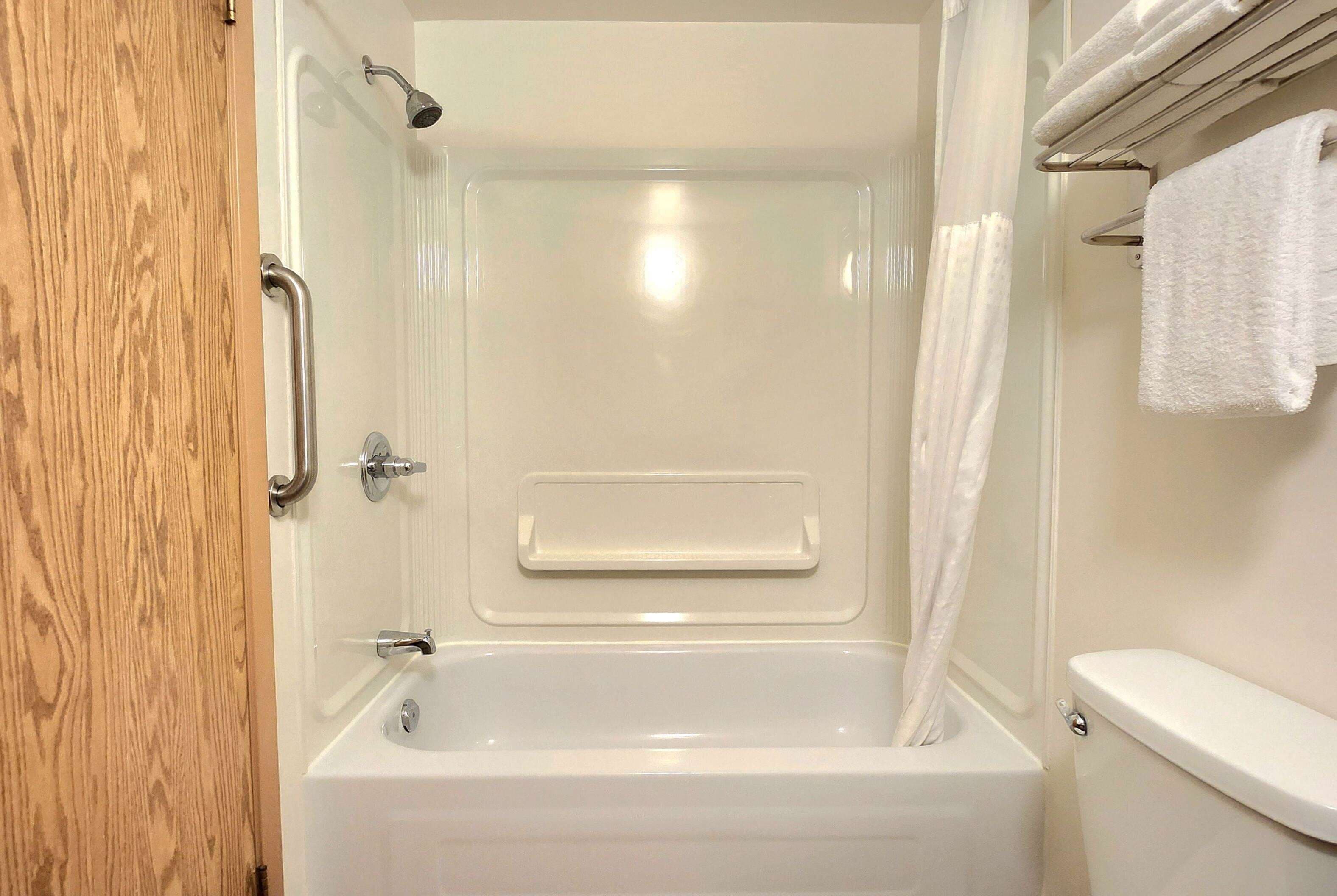 Une salle de bain équipée d’une baignoire, d’une douche, de toilettes et d’un porte-serviettes.