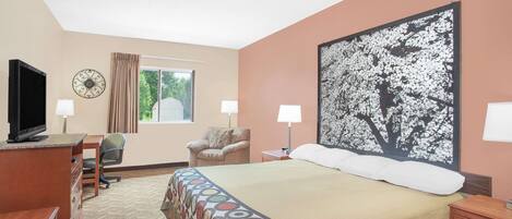 A hotel room with a bed, desk, chair, television, and artwork on the wall.