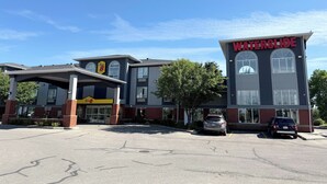 A hotel with a 'WATERSLIDE' sign, a covered parking area, and a building with large windows.