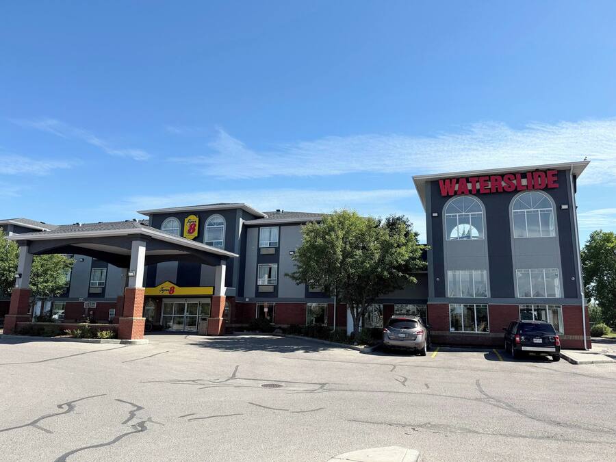 A hotel with a 'WATERSLIDE' sign, a covered parking area, and a building with large windows.